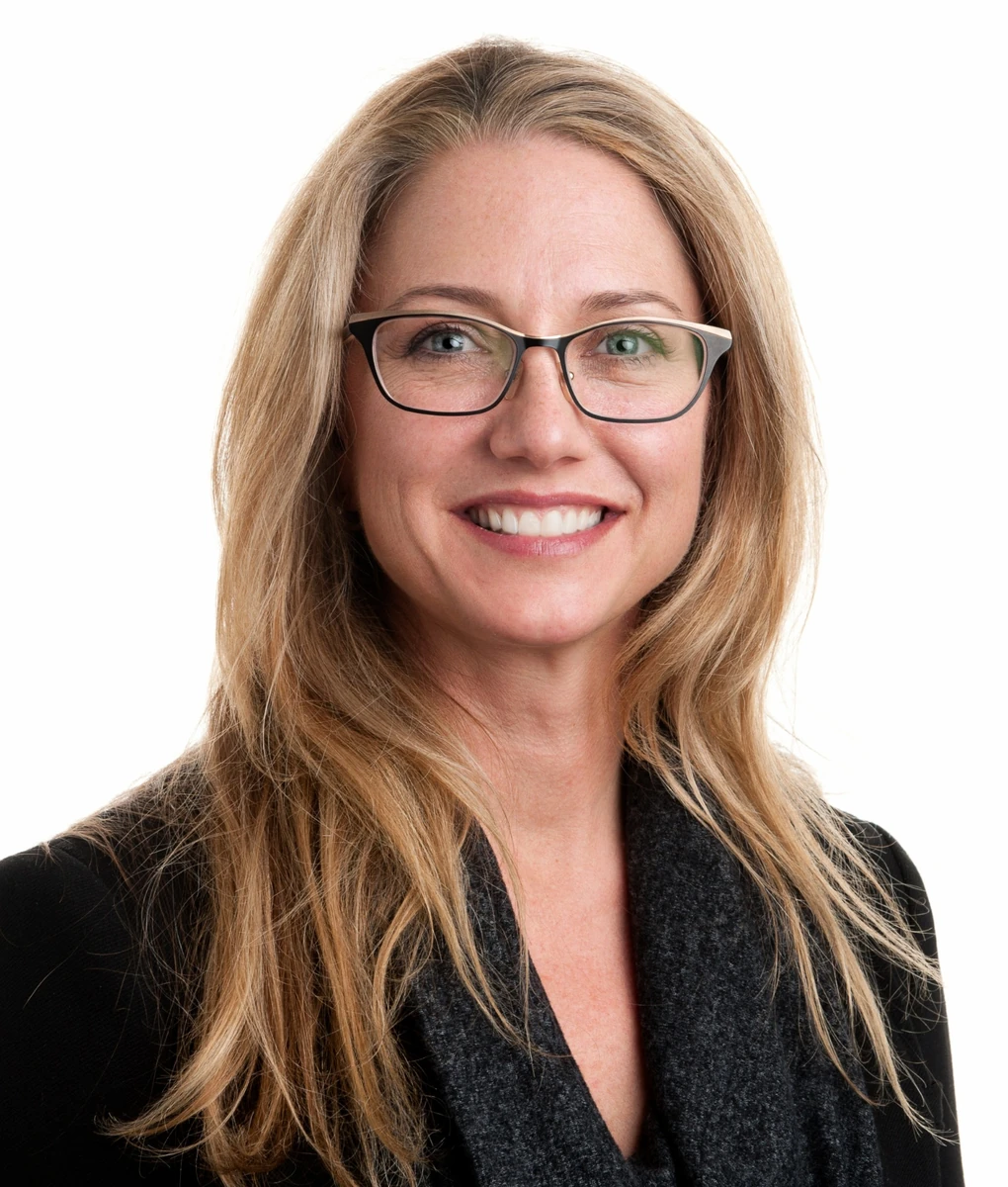 Woman wearing glasses against a light background