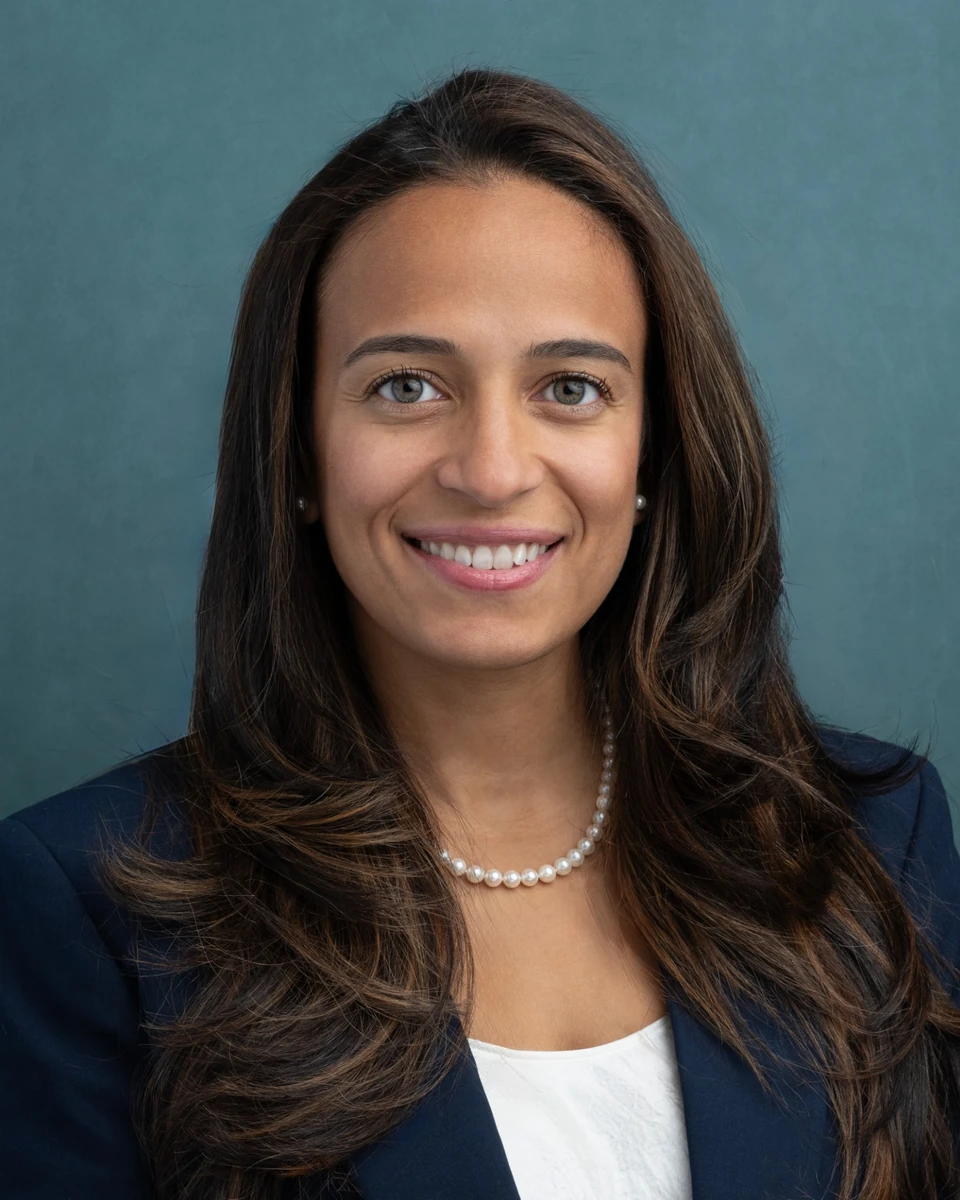 Woman in a dark blazer against a teal background