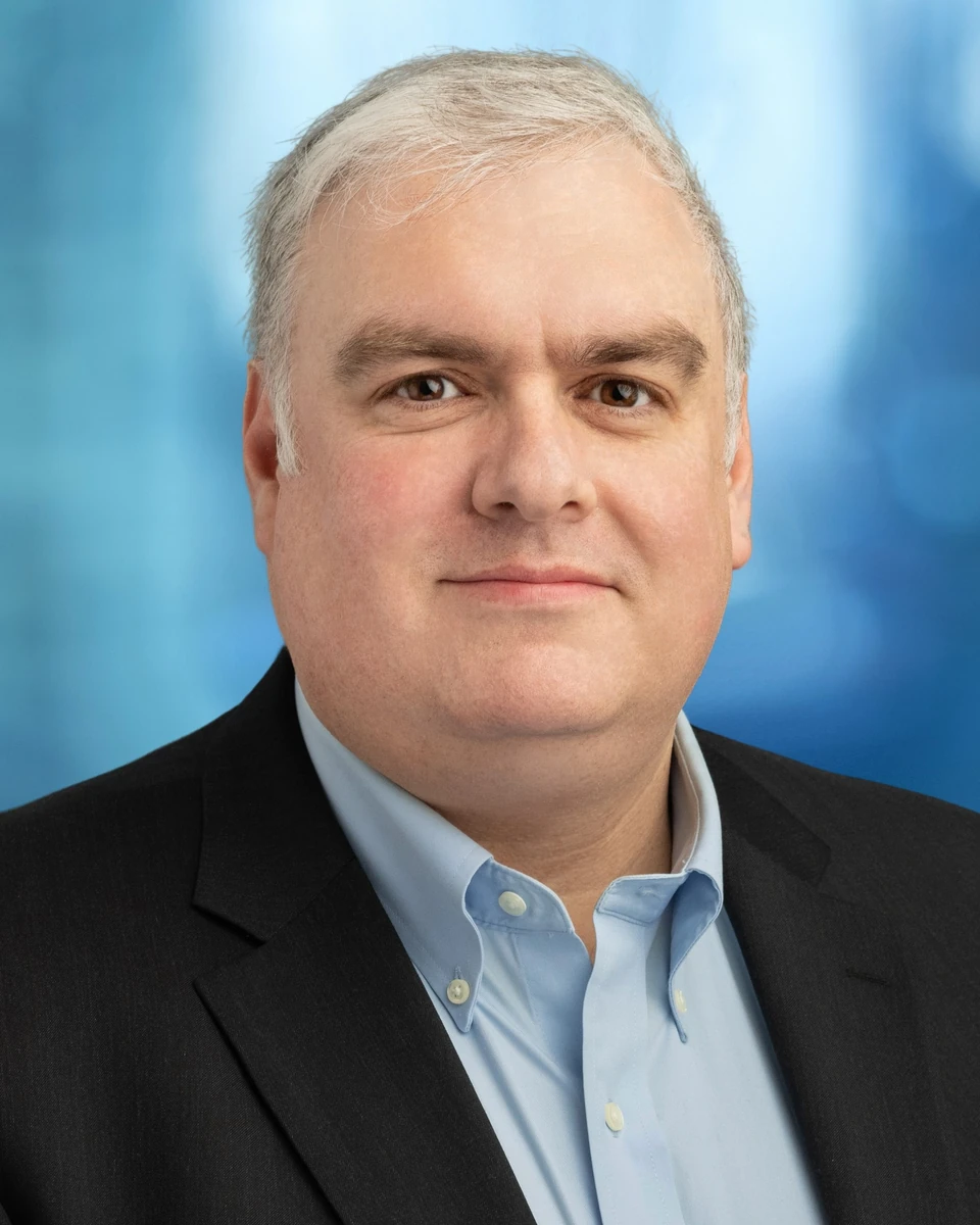 Man in a light blue shirt against a blue background