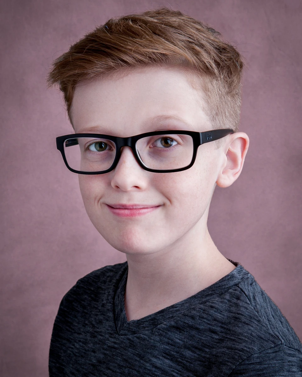 Red-haired young person wearing glasses